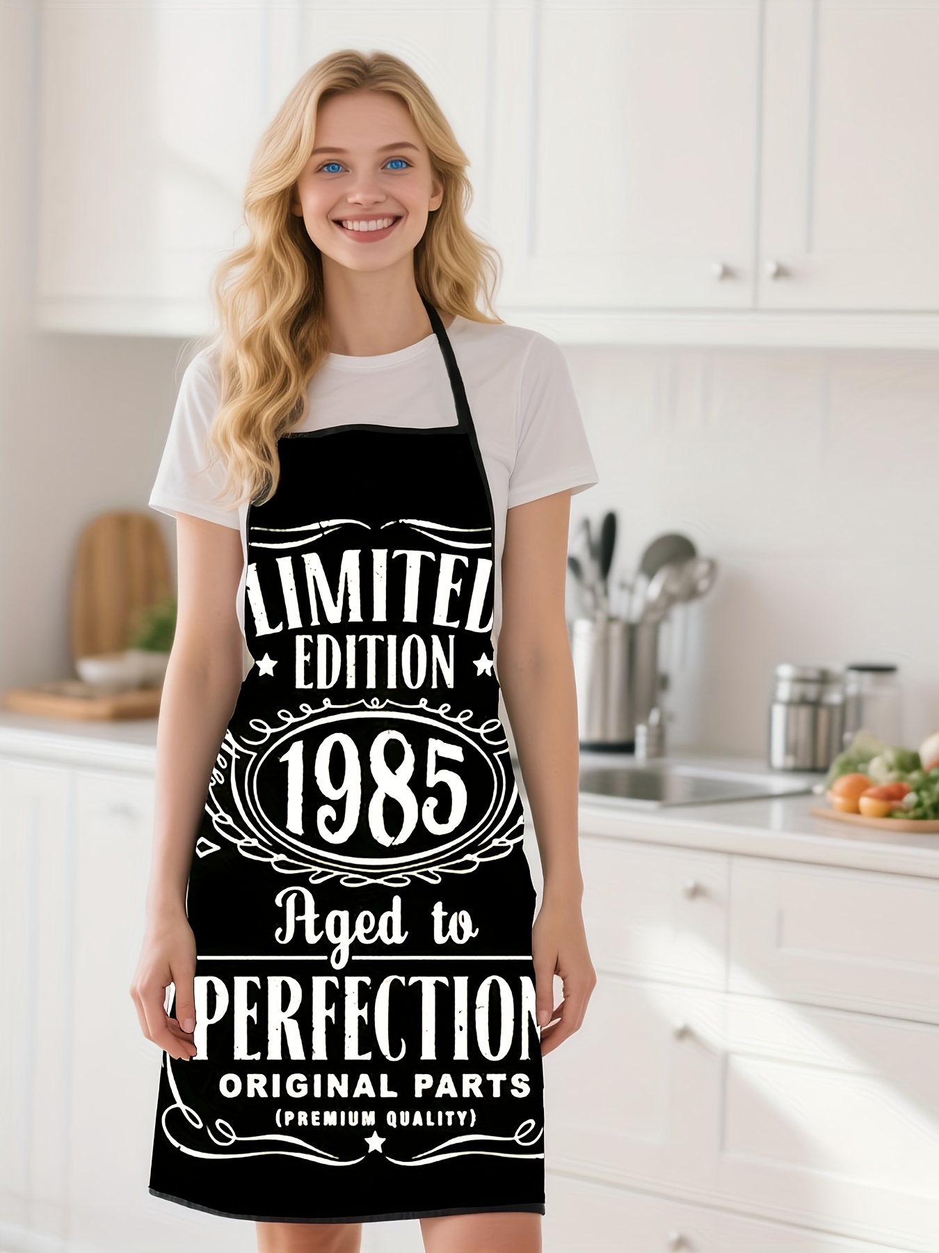 Kitchen Baking Background - 黒色の背景に「1985」のデザインが入ったキッチンエプロン、高品質で調理やベーキングに最適です。